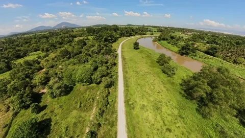 River flows beside the path under a bright blue sky Stock Footage 339827912
