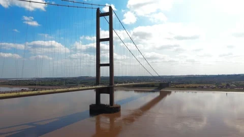 River flows calmly beneath a towering suspension bridge 库存影片 343535831