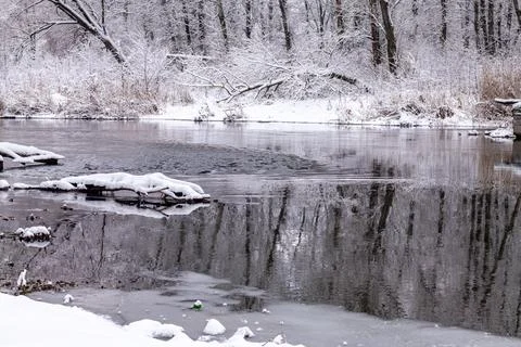 The river flows in the cold winter forest. Winter river landscape. Blurred focus Stock Photos