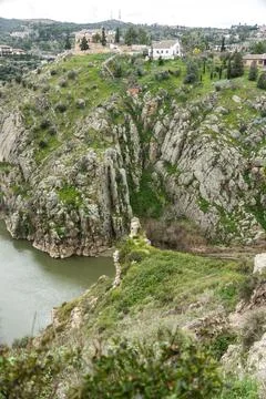 A river flows continuously through a deep valley between mountains Stock Photos