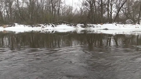 River flows in early spring, snow shore Stock Footage 73676395