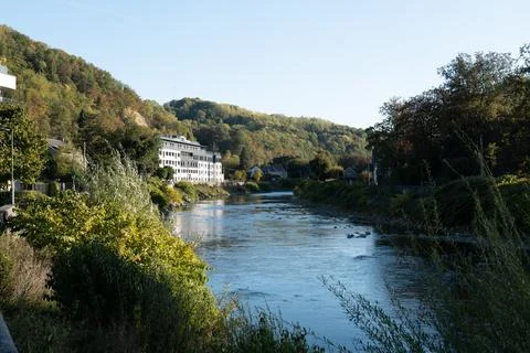River flows gently through lush, autumn-hued valley Фото