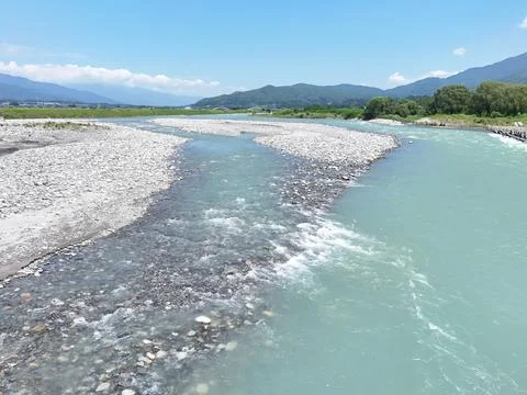 River flows gently through rocky bed Stock Photos