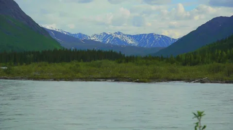 River Flows with Green Grass Backgroung and Distant Mountains Stock Footage 37436337