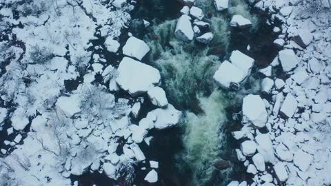 River flows in ice. Aerial top down view of the river flowing among the ice. Stock Footage 145648892