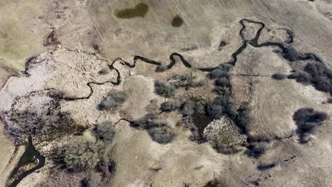 The river flows meanderingly through the field. A winding river Stock Footage 304639832