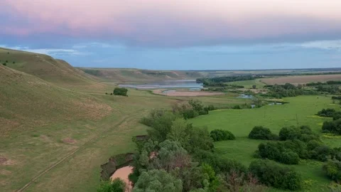 The river flows near the sole of the mountain, covered with green plants Stock Footage 155975299