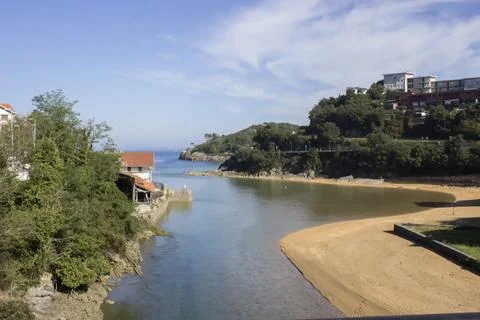The river flows into the ocean, with two banks. Stock Photos