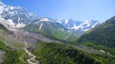 River flows out of the Shkhara Glacier aerial panorama view in sunny day Vidéo 94584025