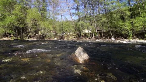 A river flows over rocks in this beautiful scene 스톡 동영상 73648470