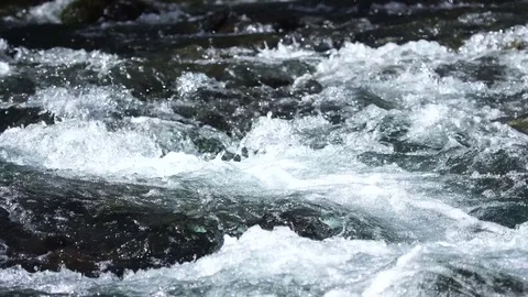 A river flows over rocks in this beautiful scene Vídeos de archivo 73648555