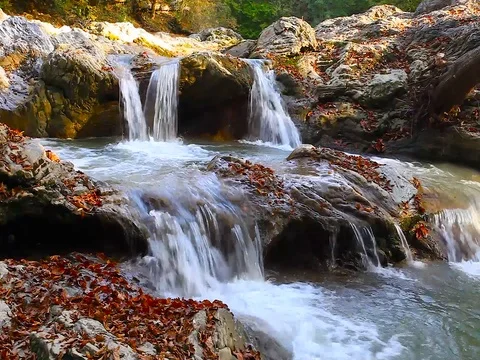 A river flows over rocks in this beautiful scene in the  mountains in autumn Stock Footage 80345204