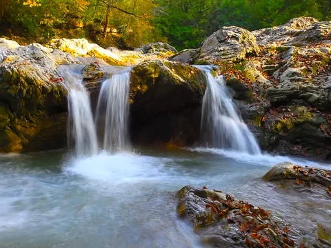 A river flows over rocks in this beautiful scene in the  mountains in autumn Vídeo Stock 80345223