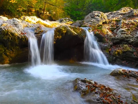 A river flows over rocks in this beautiful scene in the  mountains in autumn Stock Footage 80345239