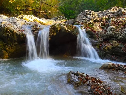 A river flows over rocks in this beautiful scene in the  mountains in autumn Vidéo 80345254