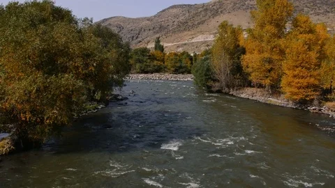 A river flows over rocks in this beautiful scene in autumn Stock Footage 82686192