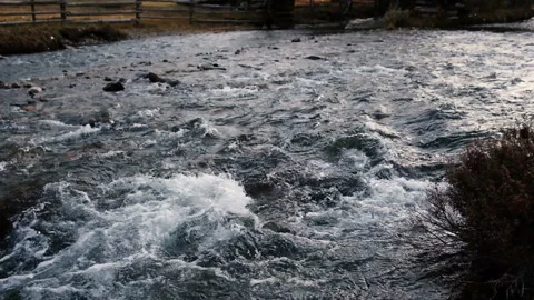 A river flows over rocks in mountain landscape. Fast flowing river. Stock Footage 86909578