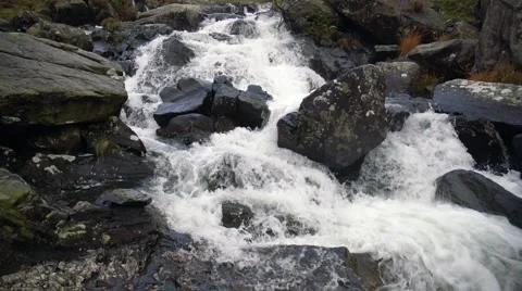 A river flows over rocks in thein the mountains Stock Footage 56590774