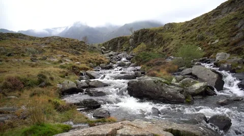A river flows over rocks in thein the mountains Stock Footage 56592507