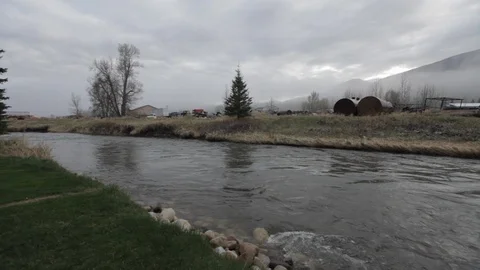 River flows by a rural location in Alberta Stock Footage 90840880