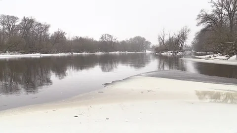 The river flows, snow-covered shore, shrubs, winter Stock Footage 73684282