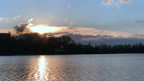 River flows at sunset with water ripples illuminating on sun rays Stock Footage 153956238