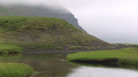 River flows through a moraine towards its mouth in glacial valley fjord Stock Footage 37272183