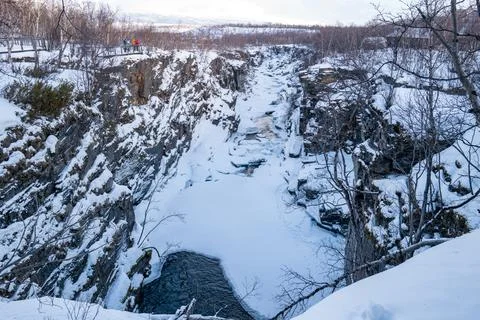 A river flows through a snow-covered canyon, surrounded by icy cliffs. Abis.. Stock Photos