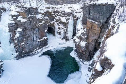 A river flows through a snow-covered canyon, surrounded by icy cliffs. Abis.. Stock Photos