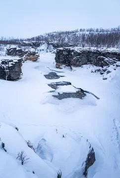 A river flows through a snow-covered canyon, surrounded by icy cliffs. Abis.. Фото