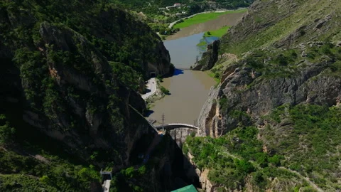 A river flows through a valley with a dam in the middle Video stock 268440031