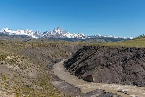 A river flows through a valley with Mount Fitz Roy in the background Stock Photos