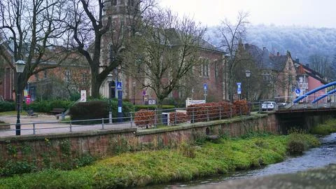 A river flows through which an old wooden bridge with a roof passes. The bridge Stock Photos