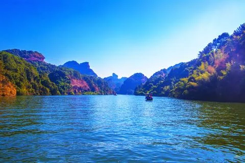 A river flows under a Karst mountain scenery Stock Photos
