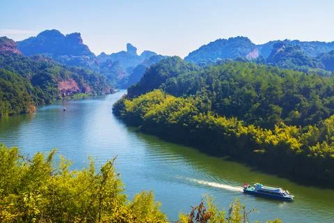 A river flows under a Karst mountain scenery Stock Photos