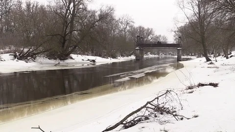 The river flows in winter, snow on the banks of the old destroyed bridge Stock-Footage 73684100