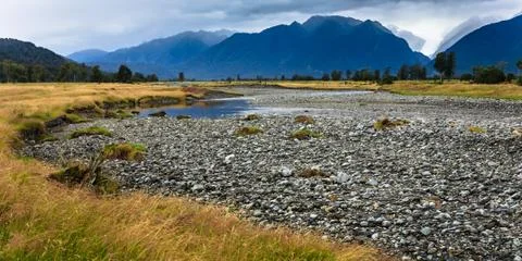 River from fox glacier with rock foreground, new zealand Stock Photos