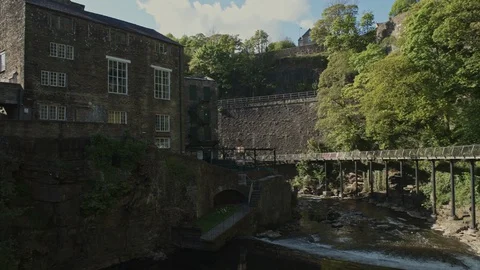 River Goyt flows over a weir and around Torr Vale Mill, New Mills 動画素材 129575869