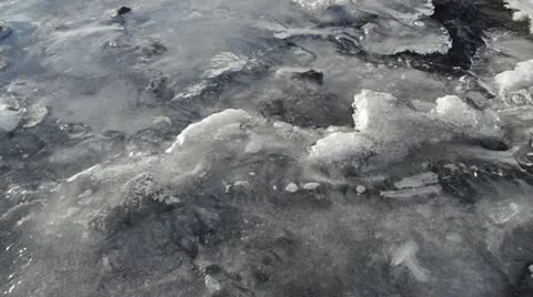 River Ice with Current and Bubbles Flowing Below Pan Stock Footage 12374305