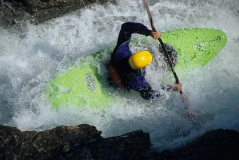 A river kayaker squeezing through the narrow gap on Beauty Creek, Alberta, Stock Photos