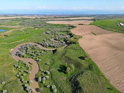 The river is in a large field 스톡 사진