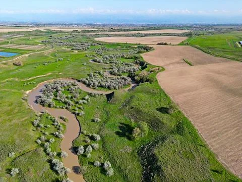 The river is in a large field Stock Photos
