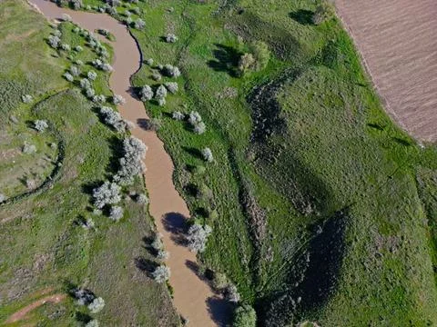 The river is in a large field Fotos de archivo