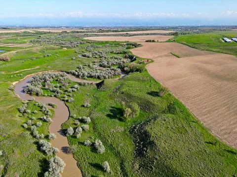 The river is in a large field Stock Photos