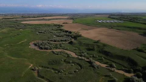 The river is in a large field for sowing crops and grazing Stock Footage 308517721