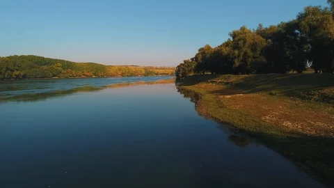 A river with lines of colorful trees on both it's coasts. Stock Footage 114432542