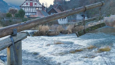 River with a lot of current with water jump from mill with village background Stock Footage 124495348