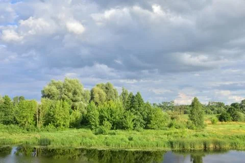 River meanders on a cloudy day, clouds in the sky. Stock Photos