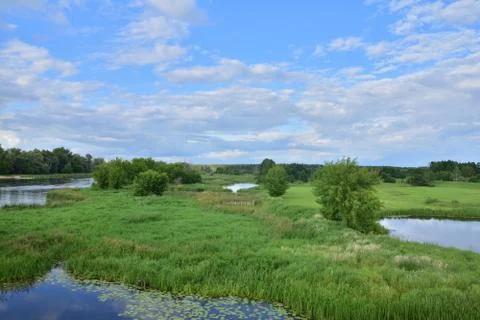River meanders on a cloudy day, clouds in the sky. Stock Photos