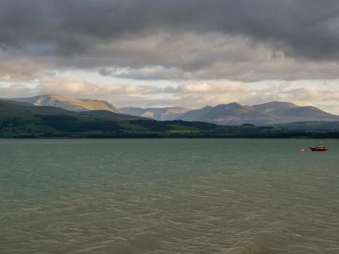 River Menai view from Anglesey, Welsh mountains hills and valleys under clouds 스톡 사진